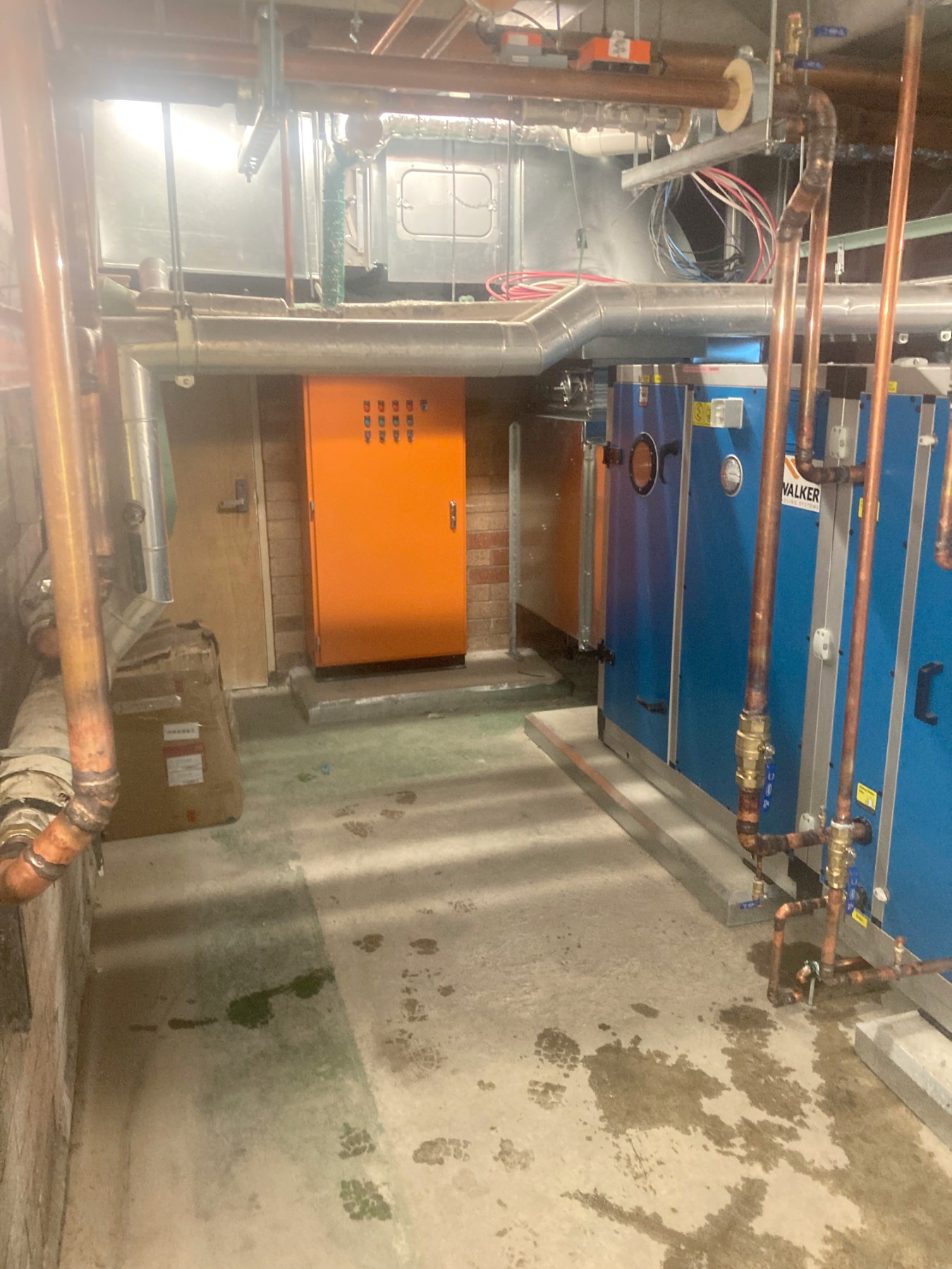 Plant room mechanical services — air handling units, copper heating hot water pipework and plant control panel.