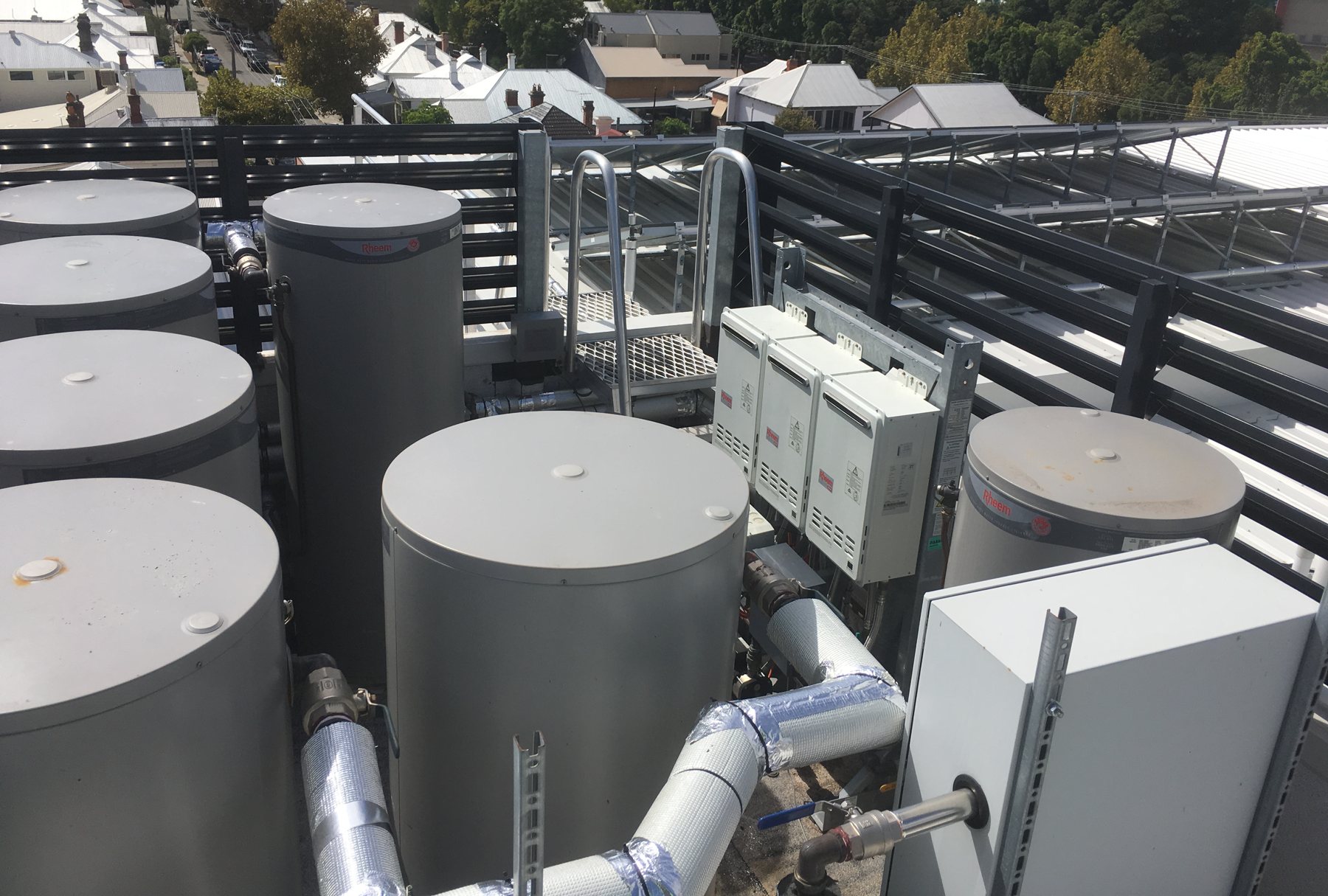 Rooftop hot water plant with storage cylinders, gas heaters and solar collectors.